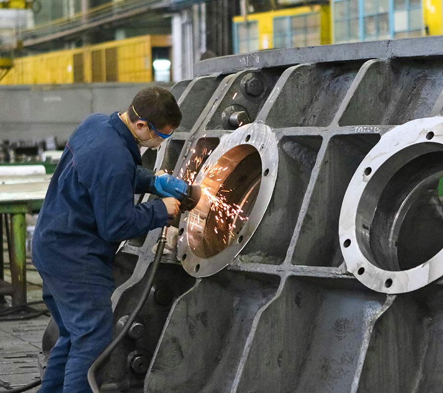 Man Using Measuring Tape in Factory Setting Man Using Measuring Tape in Factory Setting